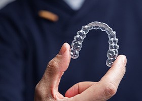 Dentist holding Invisalign tray 
