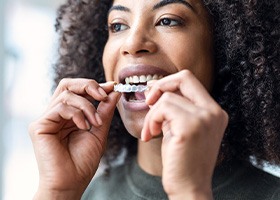 Young woman putting on Invisalign tray