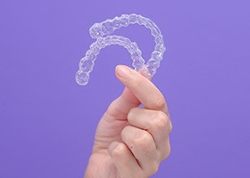 Woman holding two Invisalign aligners 