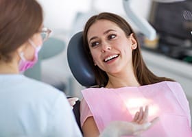 Woman in dental chair smiling at dentist