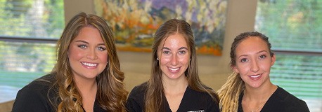 Three smiling dental team members