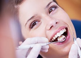 Smiling woman receiving a dental cleaning in Oklahoma City