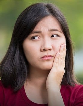 Woman holding her cheek in pain