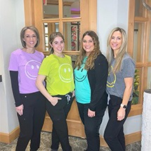 Smiling team members standing in front of Grand Dental Studio in Oklahoma City