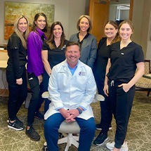 Smiling team members standing in front of Grand Dental Studio in Oklahoma City