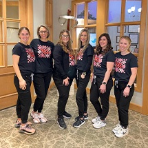 Smiling team members standing in front of Grand Dental Studio in Oklahoma City