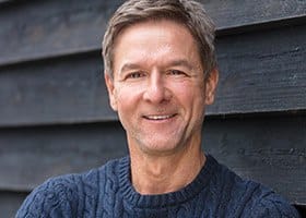 Older man smiling in blue sweater