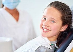 Smiling young woman in dental chair