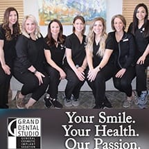 Smiling team members standing in front of Grand Dental Studio in Oklahoma City