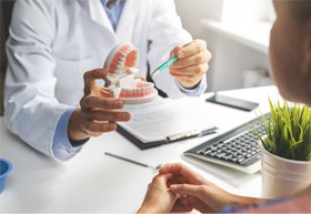 patient talking to dentist about implant dentures