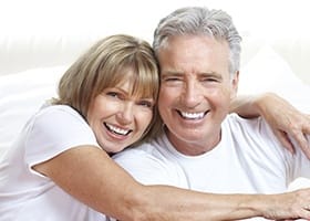 Older man and woman smiling outdoors