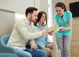 Patients looking at dental insurance brochure 
