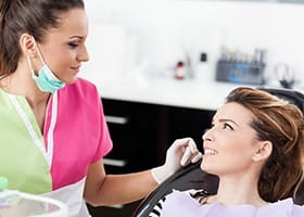 Woman in dental chair looking at assistant