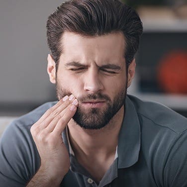 Man holding jaw in pain