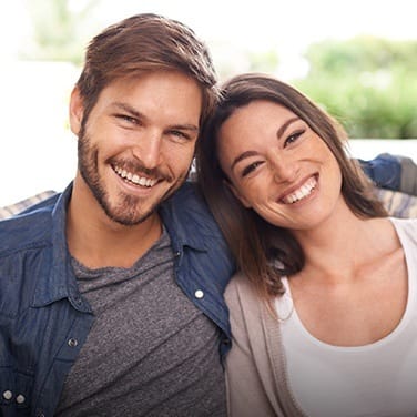 Smiling young man and woman sitting on couch