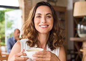 Smiling woman holding cup of coffee