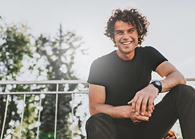 Young man smiling outdoors on sunny day