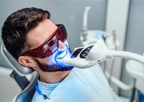 man receiving professional teeth whitening in dental chair