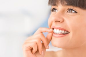 happy woman w/ Invisalign tray 