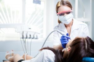 young dental hygienist in Oklahoma City performing a cleaning 
