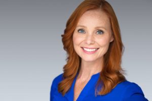 40-something year old woman smiling with blue shirt