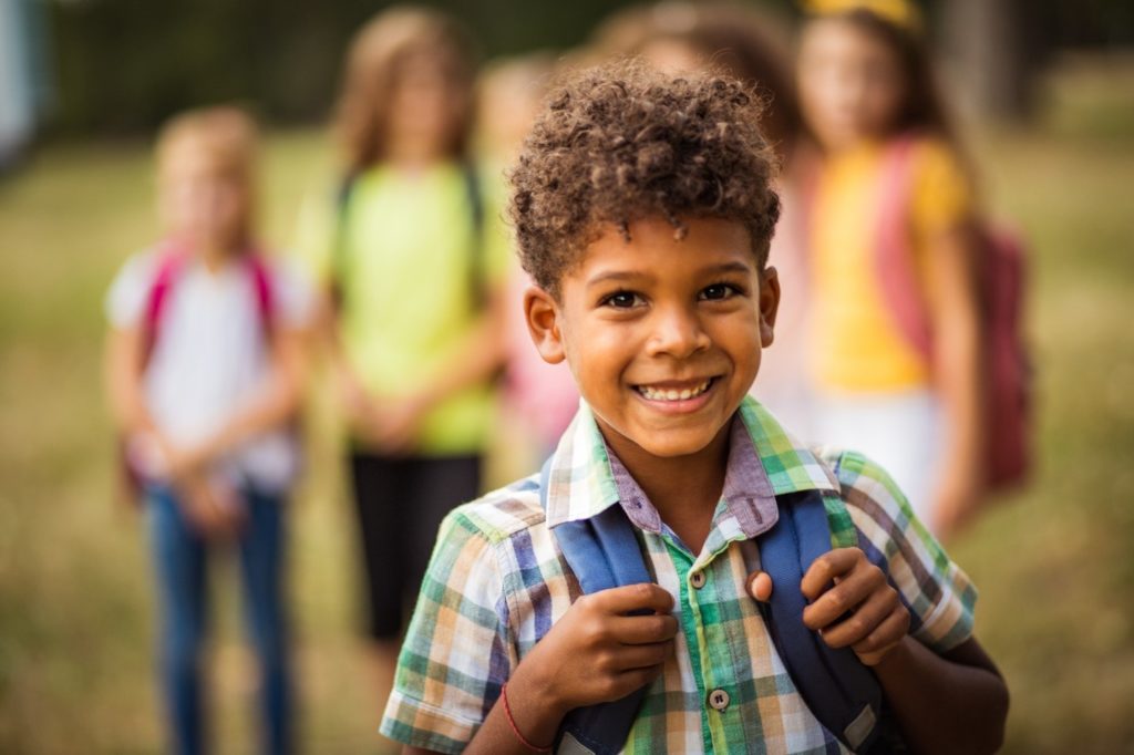 Smiling boy wearing a backpack.