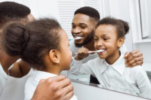 father and daughter brushing together 
