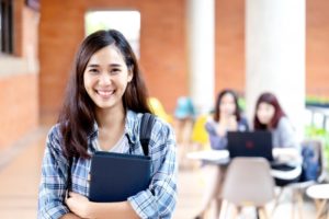 smiling female student with binder