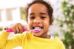 young girl brushing her teeth 