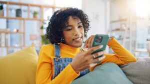 woman using phone on couch 